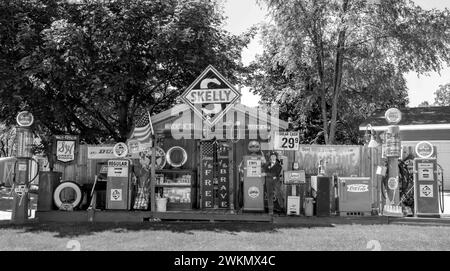 Black and white vintage Skelly memorabilia and other antique automotive objects on display in a yard on a summer day in St. Cloud, Minnesota USA. Stock Photo