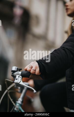 Focused image of a woman's hands gripping the handlebars of a vintage bicycle, depicting an active urban lifestyle. Stock Photo