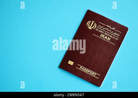 Red Islamic Republic of Iran passport on blue background close up. Tourism and citizenship concept Stock Photo