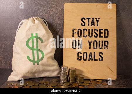 Inspirational quote - Stay focused on your goals. With text message on white paper book, pen, a cup of morning coffee, flower. Stock Photo