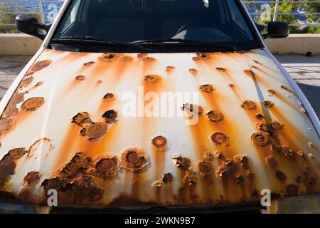 White compact size car with circular rust spots on front hood, Dubrovnik, Croatia. Stock Photo