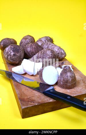 closeup of taro root vegetable, eddo malanga, hands table slice Stock Photo