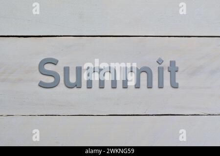 Grey Summit letters printed in 3D. Target to reach message. Letters presented on rough whitish wood board background. Stock Photo