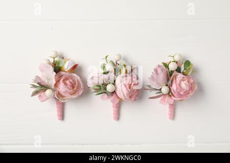Beautiful boutonnieres on white background, flat lay Stock Photo