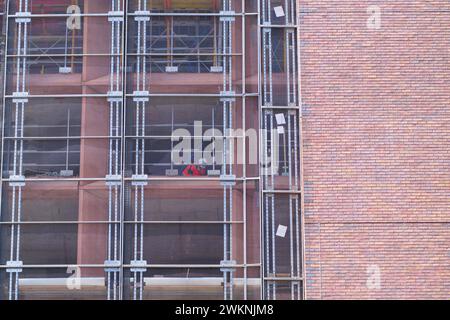Scaffolding next to brick building showing abstract square patterns on building exterior in Melbourne city, Australia. Stock Photo