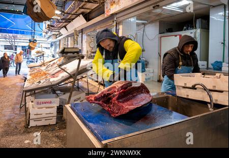 Fishmonger cutting up tuna in front of his market stall, display of fresh fish and seafood on ice, Food, Kapani Market, Vlali, Thessaloniki Stock Photo
