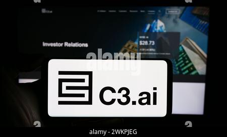 Person holding smartphone with logo of US artificial intelligence company C3.ai Inc. in front of website. Focus on phone display. Stock Photo