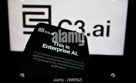 Smartphone with website of US artificial intelligence company C3.ai Inc. in front of business logo. Focus on top-left of phone display. Stock Photo