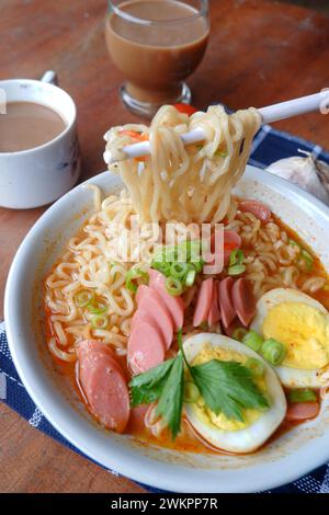 Photo of noodle soup with toppings such as sausages, eggs, and vegetables Stock Photo