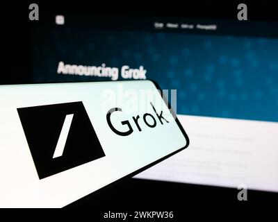 Mobile phone with logo of generative artificial intelligence chatbot Grok (X.AI) in front of website. Focus on center-left of phone display. Stock Photo