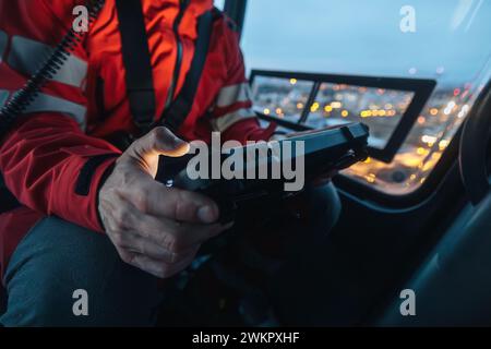 Close-up of hands of doctor inside helicopter emergency medical service while using digital tablet during a night mission flight. Stock Photo