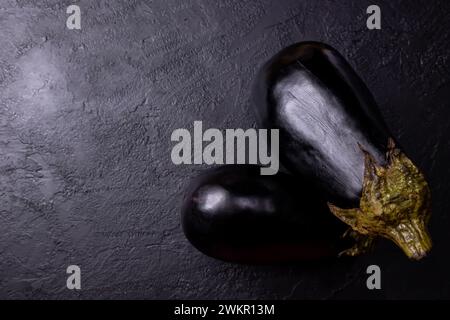 Eggplants on a black table, with low lighting. Stock Photo