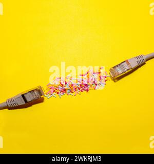 Network cable connected with sprinkles on yellow background. Creative flat lay. Copy space. Stock Photo