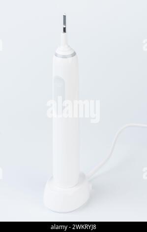 Electrical modern toothbrush on wireless charging station isolated Stock Photo