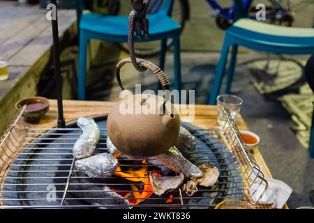 Clay pot kettle over a open pit fire during winter Stock Photo