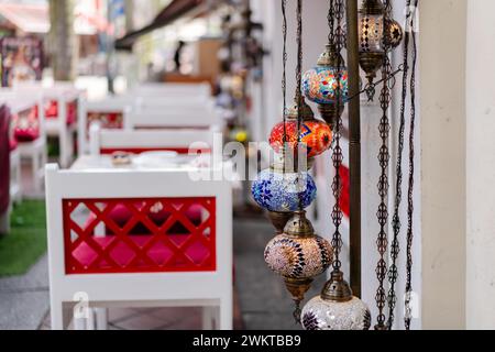 Variety of hanging lamps near a red chair on a wall Stock Photo