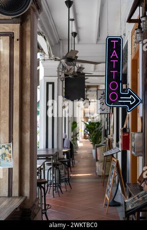 Neon-lit tattoo parlor entrance with chairs Stock Photo
