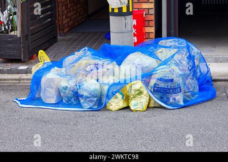 Bags with garbage on the street protected by a net waiting for the collection Stock Photo