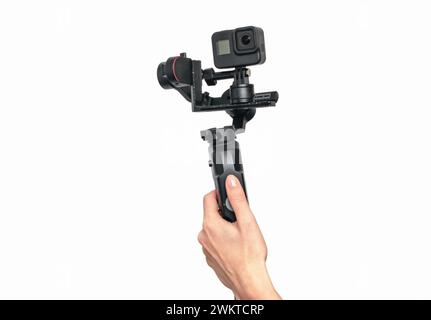 Female hand holding modern black portable stabilizer for shooting, isolated on white background. Stock Photo