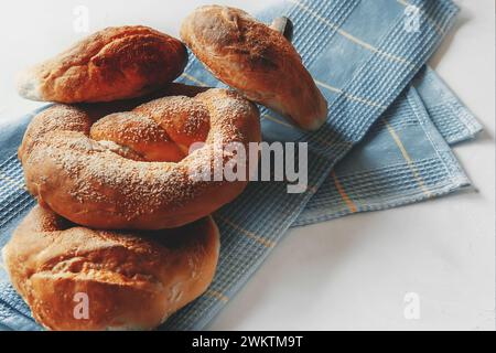 Freshly baked German pretzel and Russian pretzel. Two types of pastries on a blue napkin. Stock Photo