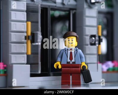 Tambov, Russian Federation - February 20, 2024 A Lego businessman minifigure standing in front of a bank while holding a suitcase in his hand. Stock Photo