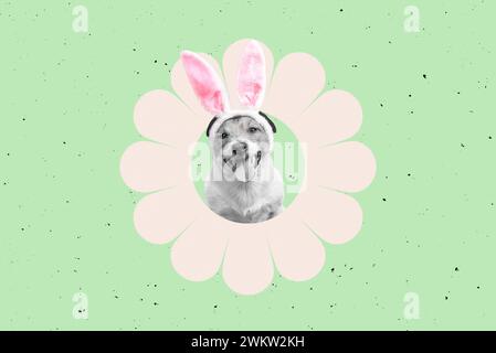 Dog with Easter bunny ears inside pink flower on green background Stock Photo