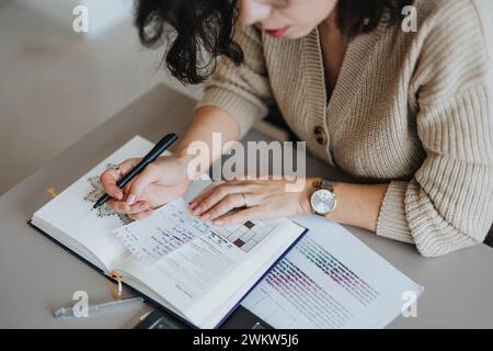 Woman writing stats or project notes down in a notebook. Stock Photo