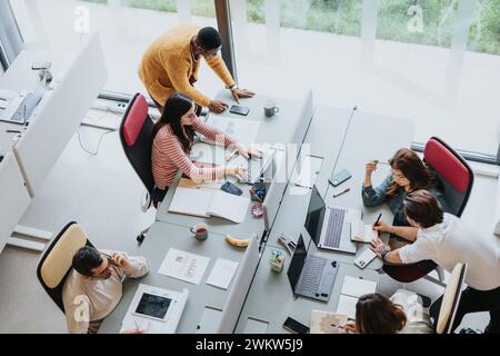 Multicultural group of coworkers collaborating in modern office. Stock Photo