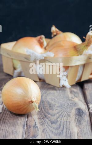 Harvest onion. Onions on a wooden background. Bulb onion close-up. Fresh harvest of onions. Agriculture. Onion for farm market, organic food, vegetari Stock Photo