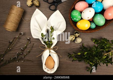 The process of making Easter decorations. Easter eggs and willow twigs on a wooden table. Stock Photo