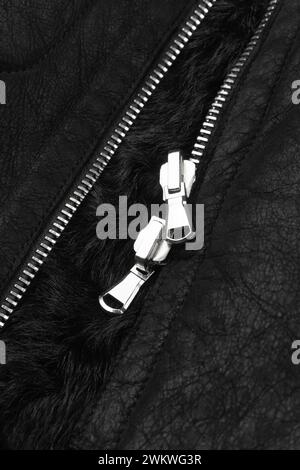 Double metal zipper on a black sheepskin coat from Shearling background close up Stock Photo
