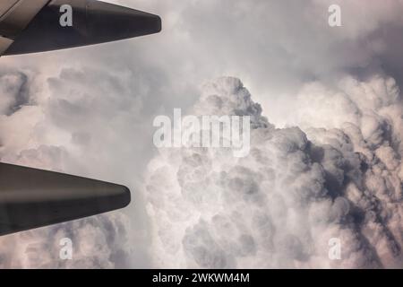 Aerial scene of cloudy sky viewed from airplane window during flight with continuous blanket of clouds. Stock Photo