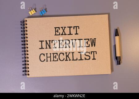 Handwritten Exit Interview Checklist Message On Notebook With Blue Marker And Spectacles Over Office Desk Stock Photo