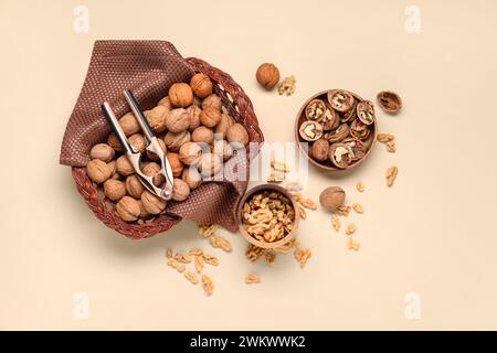Wicker basket and bowls with walnuts on yellow background Stock Photo