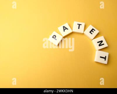 Top view toys word with text PATENT on yellow background. Stock Photo