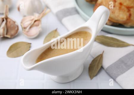 Delicious turkey gravy in sauce boat on white table, closeup Stock Photo