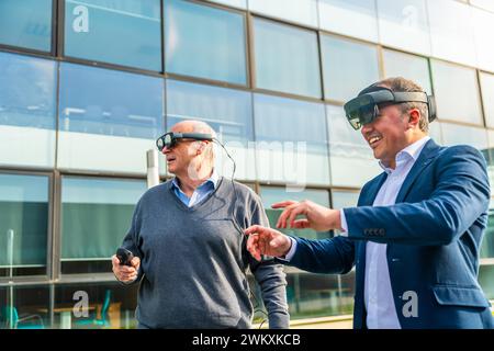 Senior and mature businessmen using the VR headset with actions outdoors next to a financial building Stock Photo