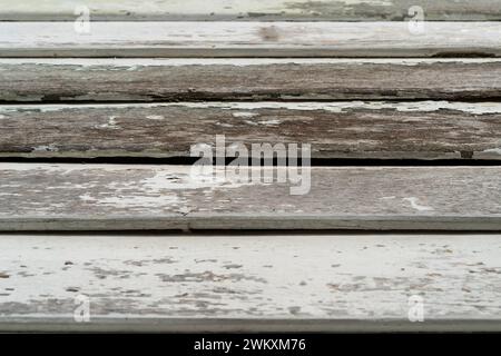 Close-up view of the old wooden building boards chipped and peeling painted white from old paint. Stock Photo