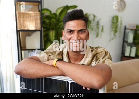 Portrait of happy man leaning on solar panel he bought Stock Photo
