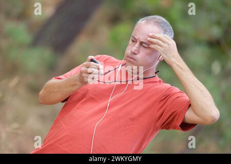 senior man exercising and sighing while looking at his stopwatch Stock Photo