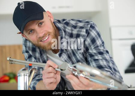 male plumber assembling metal sink hoses Stock Photo