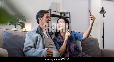 Happy old couple elderly taking selfie on cellphone, senior mature spouses wife and husband laughing holding phone make self portrait on smartphone Stock Photo