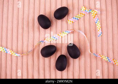 Easter flatlay of Black Chalkboard Eggs on a peach blanket Stock Photo