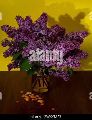 Beautiful bouquet of lilacs in a glass jar on a wooden table Stock Photo