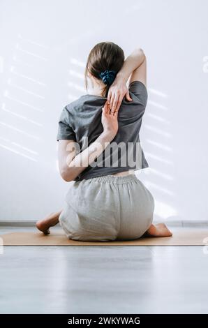 Woman in casual clothes practicing yoga at home Stock Photo