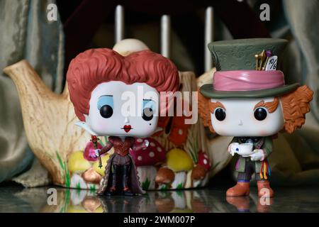 Funko Pop action figures of Red Queen and Mad Hatter, Alice in Wonderland. Handmade colorful teapot, fabulous palace, reflection floor, green curtain. Stock Photo