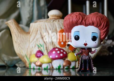 Funko Pop action figure of Red Queen from fantasy movie Alice in Wonderland. Handmade colorful teapot, fabulous palace, columns, reflection floor. Stock Photo