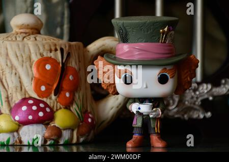 Funko Pop action figure of Mad Hatter from fantasy movie Alice in Wonderland. Handmade colorful teapot, fabulous palace, columns, reflection floor. Stock Photo