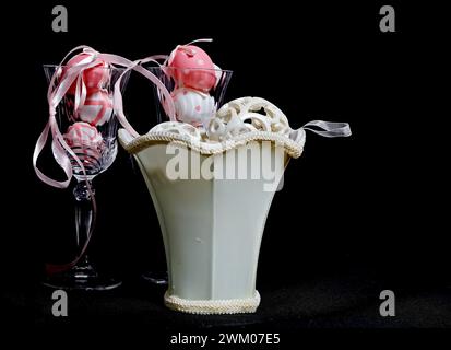 Pink and white decorative easter eggs in textile bowl and crystal glass Stock Photo