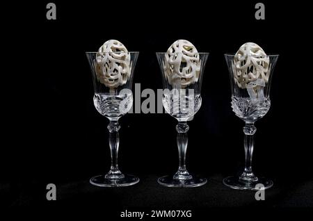 Decorative plastic easter eggs in crystal glasses with black background Stock Photo
